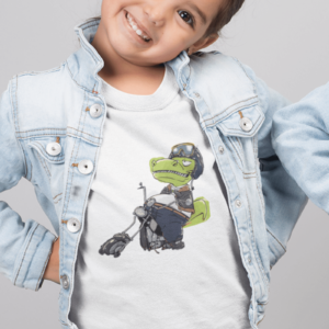 girl wearing a dinosaur shirt with a t rex on a chopper
